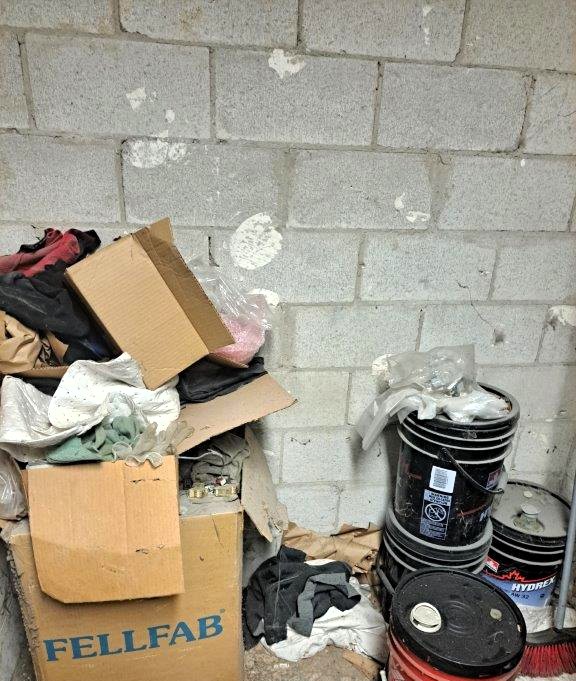 This image highlights improper storage conditions in what appears to be an elevator machine room, raising serious fire safety concerns.
Fire Protection and Code Compliance Issues
1. Combustible Materials: The presence of cardboard boxes, rags, and paper debris significantly increases the fire load in the space. If exposed to a heat source or electrical fault, these materials could ignite and allow fire to spread rapidly.
2. Flammable Liquids: The black buckets with hazard symbols suggest the storage of flammable or combustible liquids, which should be properly contained and stored in designated flammable storage cabinets per the Ontario Fire Code.
3. Egress Obstruction: The cluttered space can obstruct access to critical equipment, delaying response times for maintenance personnel and firefighters in an emergency. The Ontario Fire Code requires clear and unobstructed access to fire protection systems.
4. Elevator Safety Hazards: Elevator machine rooms house electrical and mechanical systems that must be free from unrelated storage, as per ASME A17.1 (Safety Code for Elevators and Escalators) and NFPA 70 (National Electrical Code - NEC 620.2). Unrelated storage can interfere with cooling systems, increase fire risk, and hinder emergency shutdown procedures.
Recommended Actions
✔ Remove all non-essential storage and keep the room free from combustible materials.
✔ Store flammable liquids in an approved flammable storage cabinet away from ignition sources.
✔ Ensure proper housekeeping to maintain a clear and safe environment for maintenance and emergency response personnel.
✔ Verify compliance with local fire codes and NFPA standards to avoid violations and ensure life safety.
Failure to address these issues can lead to code violations, increased fire risks, and potential liability in case of an incident. Immediate corrective action is strongly recommended.