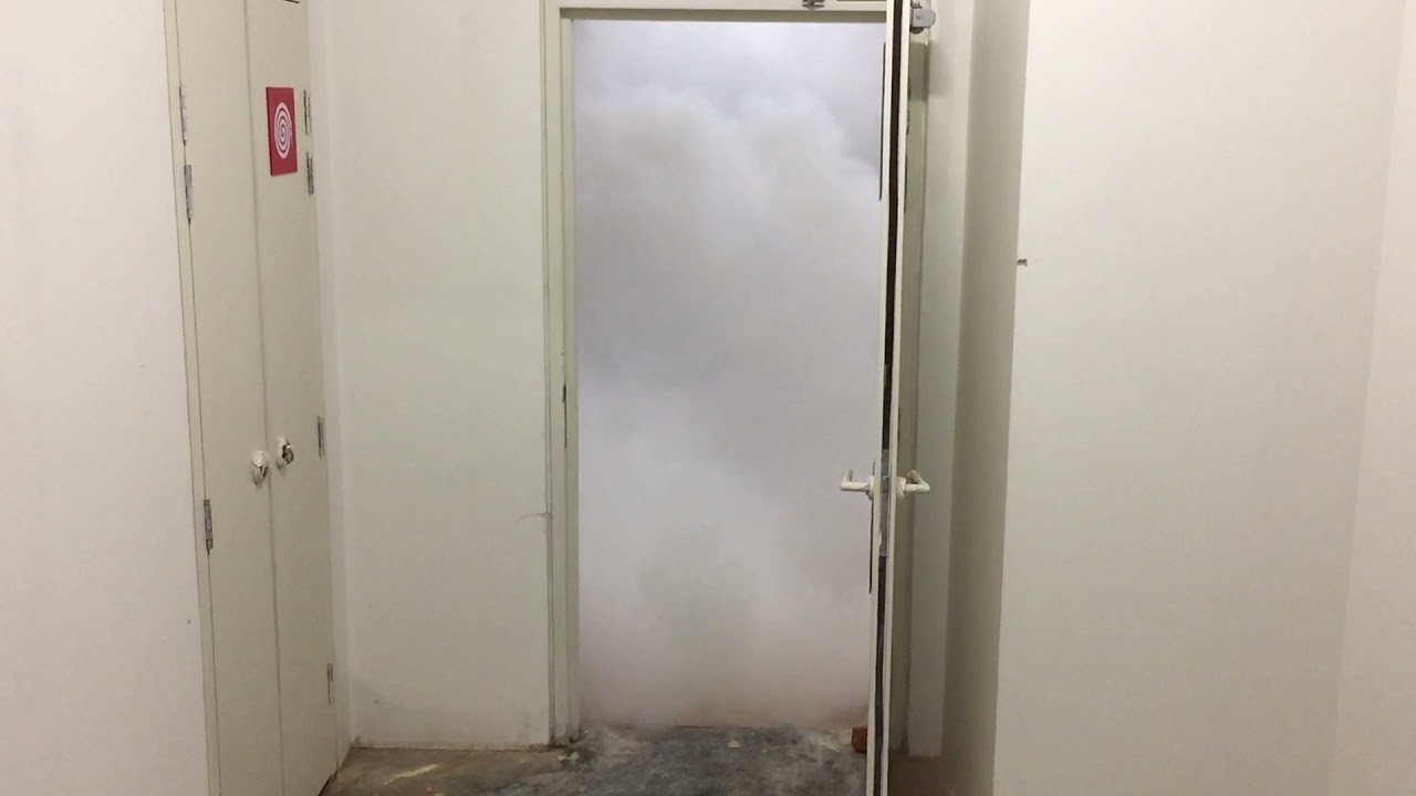 This image depicts a door leading to a smoke-filled area, likely a floor area. This situation is highly dangerous and raises critical concerns about fire safety and smoke management in the building. Fire Safety Concerns & Considerations:
Smoke Infiltration & Stairwell Pressurization Failure Stairwells should be kept clear of smoke through proper pressurization systems to maintain a safe evacuation route.
A failure in the stairwell pressurization system may allow smoke to enter, creating hazardous conditions for evacuees.
Door Integrity & Fire Rating Fire doors must be properly sealed and self-closing to prevent smoke from spreading.
Ensure that fire-rated doors and gaskets are intact and compliant with fire codes.
Smoke Control Systems & Ventilation If this is part of a mechanical smoke shaft, the smoke management system must be assessed for proper functioning.
Testing and maintenance of smoke extraction systems are crucial for keeping escape routes clear.
Evacuation & Emergency Planning If a primary exit route (such as a stairwell) is compromised by smoke, alternative escape routes must be clearly indicated.
Occupants should be trained on emergency evacuation procedures, including avoiding smoke-filled areas.
Immediate Recommendations:
✅ Inspect and test stairwell pressurization fans and smoke exhaust systems.
✅ Verify fire door closures, seals, and gaps for compliance.
✅ Conduct fire drills to ensure building occupants are prepared for emergency scenarios.
✅ Review and update the fire safety plan to address stairwell smoke infiltration risks.