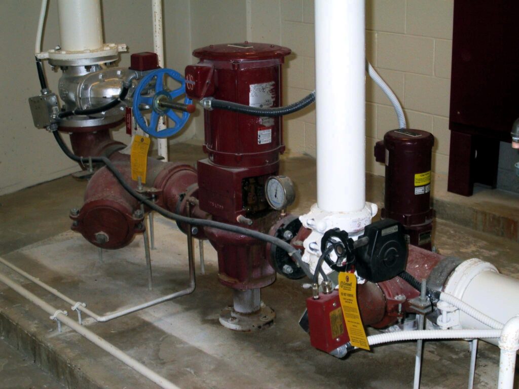 This image shows an electric fire pump system within a fire protection setup, specifically a standpipe system pump. Proper operation of this system is critical for maintaining fire safety and ensuring sufficient water pressure for firefighting operations. Fire Protection Observations
Electric Fire Pump & Control Components The electric fire pump motor is visible, along with controllers and associated piping.
The system appears to be a part of a standpipe or sprinkler system, essential for high-rise buildings or large facilities.
Electrical conduit connections must be inspected for damage, corrosion, or loose fittings, as these can impact pump reliability.
Supervisory Tamper & Control Valves The OS&Y (Outside Stem and Yoke) valve and other control valves are tagged, indicating they are either closed for maintenance or locked in an operational position.
Tamper switches and electrical supervision ensure proper valve status monitoring to prevent accidental shutdowns.
Pump Testing & Maintenance Requirements Pressure gauges should be monitored to confirm adequate suction and discharge pressures.
NFPA 25 (Standard for Inspection, Testing, and Maintenance of Water-Based Fire Protection Systems) requires weekly churn tests and annual flow tests for fire pumps.
The pump room should have adequate ventilation to prevent overheating of electrical components.
Recommendations for Fire Safety Compliance
✔ Ensure fire pump controllers are functional and free from faults, per NFPA 20 standards.
✔ Verify the electrical supply and emergency power backup to ensure pump operation during an outage.
✔ Confirm valves are in their proper position and under fire alarm system supervision.
✔ Conduct routine performance tests to verify that the pump meets required flow and pressure rates. This fire pump system is a critical life safety component, and its reliability is essential in the event of a fire. Regular testing and maintenance are key to ensuring compliance with fire protection standards.